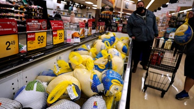 People shop for frozen turkeys for Thanksgiving dinner at a grocery store in Mount Prospect, Ill., Wednesday, Nov. 17, 2021. First, the good news: There is no shortage of whole turkeys in the U.S. this Thanksgiving. But those turkeys — along with other holiday staples like cranberry sauce and pie filling — could cost more.