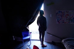 In this Feb. 23, 2021, file photo, Ricki Mills looks out from her home as she waits for a fire hydrant to be turned to get water, in Dallas on Feb. 23, 2021. Texas is again at high risk of power blackouts this winter because of extreme weather like the catastrophic February storm that buckled the state's electric grid and left millions of people without heat for days, regulators said Thursday, Nov. 18, 2021.