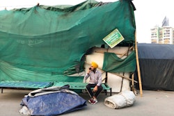 A Sikh farmer talks on the mobile phone as farmers dismantle temporary structures used for their year long protests at Ghazipur, outskirts of New Delhi, India on Dec.9, 2021.