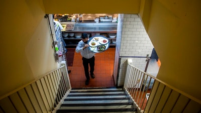Muhammad Rahman delivers orders at Gotham restaurant on Dec. 14, 2021 in New York.