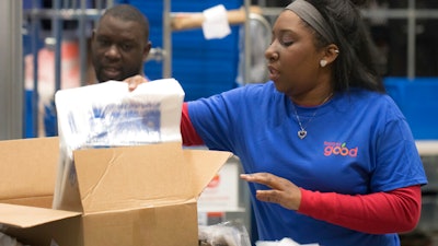 In this 2018 photo provided by Holt Haynsworth, Portia Thomas packs boxes at the Food For Good Warehouse in Austin, Texas.