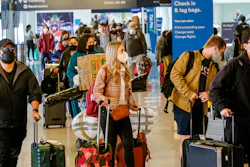 Holiday travelers wearing face masks line to check in at the Los Angeles International Airport in Los Angeles on Dec. 22, 2021.