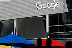 People walk by a Google sign on the company's campus in Mountain View, Calif., on Sept. 24, 2019. Google and Ford Co. are among those once again delaying their return-to-office plans, while other businesses whose workers are already back to the office are considering adding extra precautions like masks and doing COVID-19 testing.