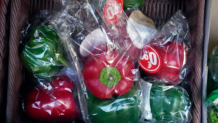 Peppers wrapped in plastic package are on display on a grocery stall in Paris on Dec. 31, 2021.