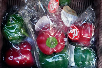 Peppers wrapped in plastic package are on display on a grocery stall in Paris on Dec. 31, 2021.