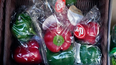 Peppers wrapped in plastic package are on display on a grocery stall in Paris on Dec. 31, 2021.