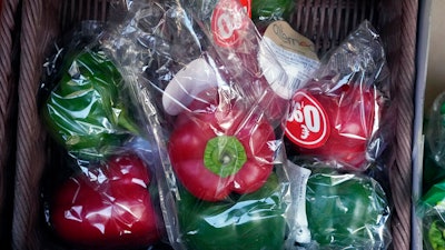 Peppers wrapped in plastic package are on display on a grocery stall in Paris on Dec. 31, 2021.