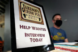 A hiring sign is shown at a booth for Jameson's Irish Pub during a job fair on Sept. 22, 2021, in the West Hollywood section of Los Angeles.