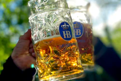 People toast with their beer mugs at the 'Taxisgarten' beer garden in Munich, Germany on May 15, 2021.