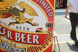 A man walks near an advertisement of a Kirin brand beer in Tokyo on Aug. 25, 2020.