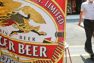 A man walks near an advertisement of a Kirin brand beer in Tokyo on Aug. 25, 2020.