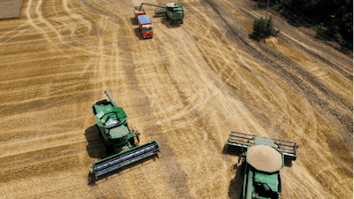 Farmers harvest with their combines in a wheat field near the village Tbilisskaya, Russia, ON July 21, 2021.