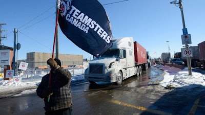 A Canadian Pacific Railway worker walks the picket line while on strike at the Cote Saint-Luc railyard in Montreal on Feb. 16, 2015.