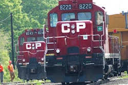 Surveyors work next to Canadian Pacific Rail trains which are parked on the train tracks in Toronto on May 23, 2012.