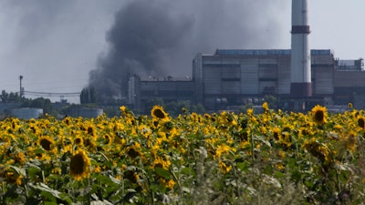 Smoke from an oil refinery rises over a field of sunflowers near Lisichansk, Ukraine, July 26, 2014.