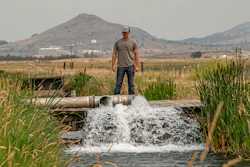Justin Grant watches water flow from his agricultural well, Klamath Falls, Ore., July 24, 2021.