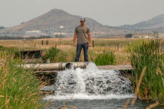 Justin Grant watches water flow from his agricultural well, Klamath Falls, Ore., July 24, 2021.
