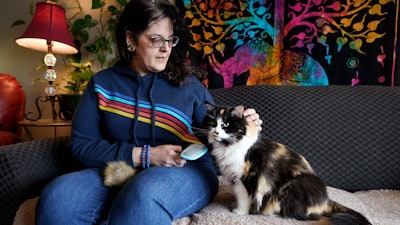 Tara Kramer with her cat, Busy, in her apartment in Des Moines, Iowa, April 8, 2022.