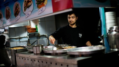 A worker fries seafood in a restaurant in Besiktas, Istanbul, April 19, 2022.