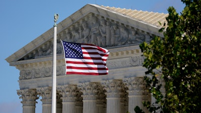An American flag blows in the wind in front of the Supreme Court building on Capitol Hill in Washington, Nov. 2, 2020.