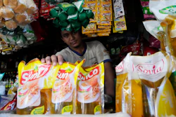A vendor shows packs of cooking oil at his stall at a market in Jakarta, April 17, 2022.
