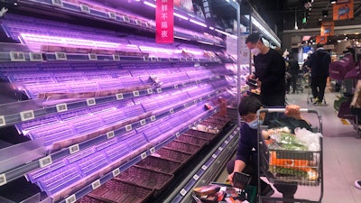 Customers look through empty shelves at a supermarket in Shanghai, China, on March 30, 2022. Residents of Shanghai are struggling to get meat, rice and other food supplies under anti-coronavirus controls that confine most of its 25 million people in their homes, fueling frustration as the government tries to contain a spreading outbreak.