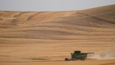A combine harvests wheat near Pullman, Wash., Aug. 5, 2021.