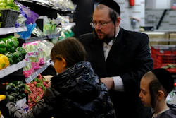 Eliot Spitzer selects vegetables at a kosher supermarket with two of his seven children, Faigy, right, and Abba, Williamsburg, Brooklyn, New York, April 19, 2022.