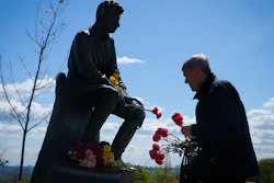 A man lays flowers at an Unknown Soldier Tomb to mark Victory Day in World War II, Kyiv, Ukraine, May 9, 2022.