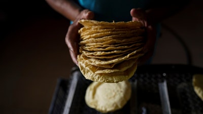 A worker packages tortillas to sell for 20 Mexican Pesos per kilogram — about one dollar — at a tortilla factory in Mexico City, May 9, 2022.