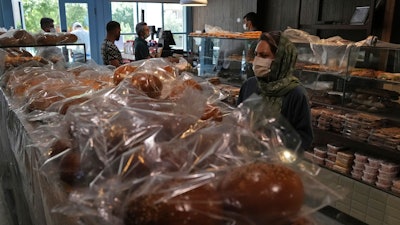 A customer buys bread in a bakery in Tehran, May 11, 2022.