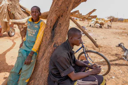 People lean on a tree in Djibo, Burkina Faso, May 26, 2022.
