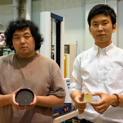 Tokyo University researchers Yuya Sakai, right, and Kota Machida pose for photos with products they made out of 'food cement' at their laboratory in Tokyo, May 26, 2022.