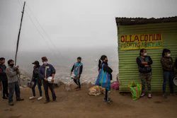 Residents wait in line at a 'community pot' in the Nueva Esperanza neighborhood of Lima, Peru, June 17, 2020.