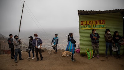 Residents wait in line at a 'community pot' in the Nueva Esperanza neighborhood of Lima, Peru, June 17, 2020.
