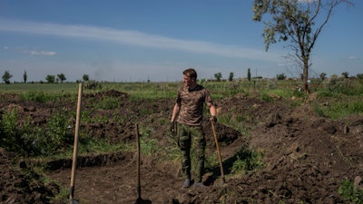 A Ukrainian serviceman digs trenches near the frontline in Donetsk region, June 8, 2022.