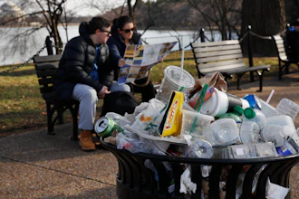 A trash can overflows as people sit outside of the Martin Luther King Jr. Memorial, Washington, D.C., Dec. 27, 2018.