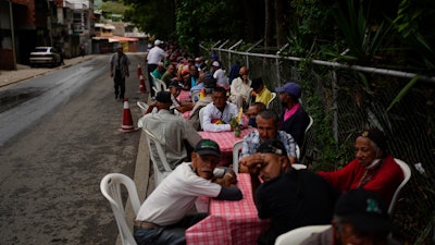 Residents wait for lunch donated by the New Birth's Christian church, Caracas, Venezuela, June 8, 2022.