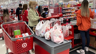 A customer wears a mask as she waits to get a receipt at a register in Target store in Vernon Hills, Ill., May 23, 2021.