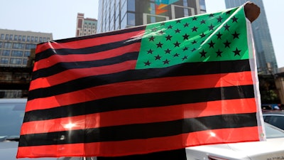 A man holds an African-American flag during a demonstration in Chicago, June 19, 2020.