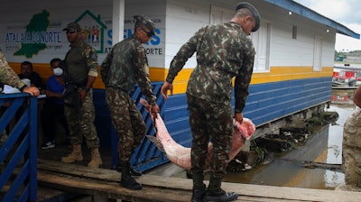 Army soldiers carry seized fish illegally caught in Atalaia do Norte, Brazil, June 11, 2022.