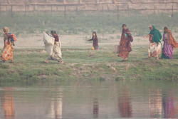 Women walk along the Yamuna River, Agra, India.