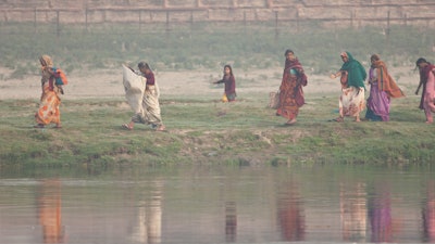 Women walk along the Yamuna River, Agra, India.