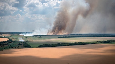 Smoke rises from the front lines with farm fields in the foreground, Dnipropetrovsk region, Ukraine, July 4, 2022.