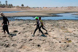 People cross the Diyala River near Baghdad, June 29, 2022.