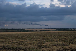 Grain fields backdropped by a power plant in the Donetsk region, Ukraine, July 22, 2022.