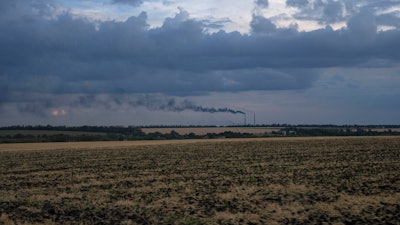 Grain fields backdropped by a power plant in the Donetsk region, Ukraine, July 22, 2022.