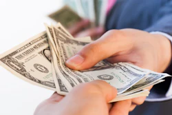Business Man Giving Bank Notes To Another Person 516934262 2125x1416 (1)