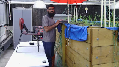 Abdul Salam takes measurements in a test bed at Purdue University to determine the optimum operating frequency for underground antennas.