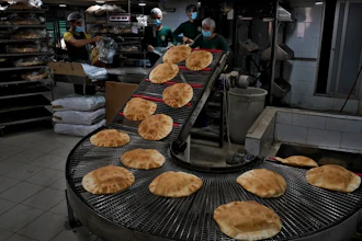 Workers package bread coming off a production line at an automated bakery in Dahiyeh, Lebanon, March 15, 2022.